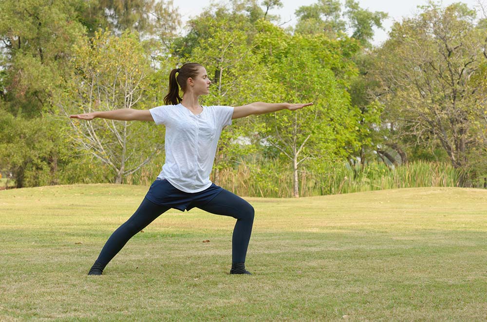 Beneficios del Qi Gong: mujer practicando meditación en movimiento al aire libre